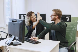 Symbolbild: IT-Support. High-Five nach erfolgreich gelöstem Support-Fall.